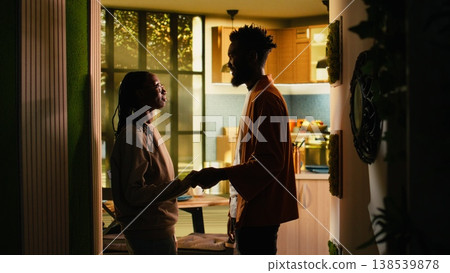 Loving black couple holding hands after fight, enjoying calm reconciliation moment indoors. Man and woman show forgiveness, bonding and emotional connection, healthy relationship unity. Loving black couple holding hands after fight, enjoying calm reconciliation moment indoors. Man and woman show forgiveness, bonding and emotional connection, healthy relationship unity. 138539878