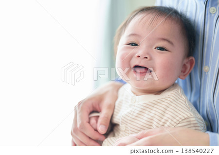 A baby held by a father A baby held by a father 138540227