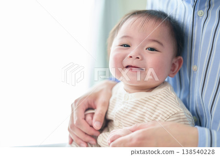 A baby held by a father A baby held by a father 138540228
