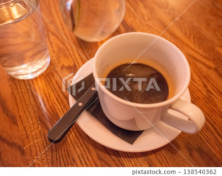[烏克蘭] 在首都基輔的一家咖啡館裡，一張木桌上放著一個玻璃杯和一杯白咖啡。 138540362