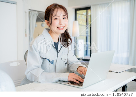 一位身穿工作服的女士正在辦公室工作。 一位身穿工作服的女士正在辦公室工作。 138540757