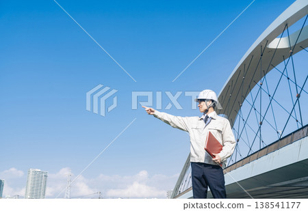一名男工人站在橋上凝視遠方。 一名男工人站在橋上凝視遠方。 138541177