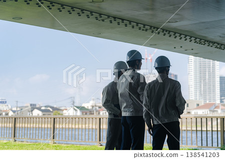 A group of male workers looking out at the city 138541203