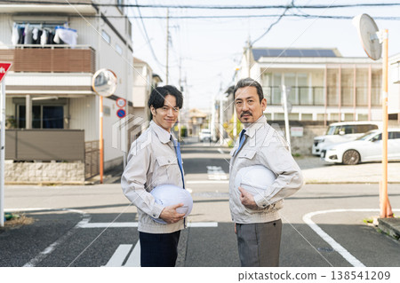 一群男性工人站在居民區。 138541209