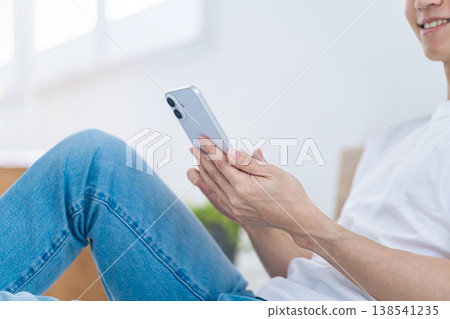 一名男子悠閒地使用智慧型手機。 138541235