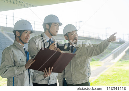 A group of male workers taking pictures of the facility with a camera. 138541238