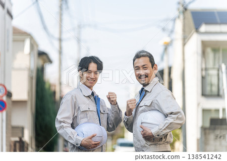 A group of male workers standing in a residential area 138541242