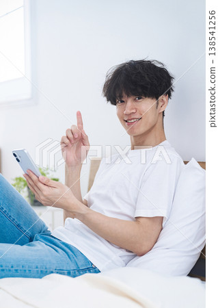 一名男子悠閒地使用智慧型手機。 138541256