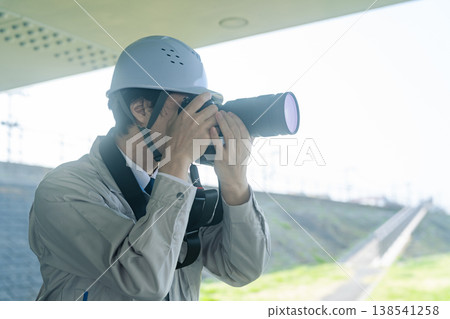 一名男工人正在用相機拍攝工廠設施。 138541258