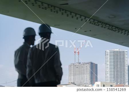 A group of male workers looking out at the city A group of male workers looking out at the city 138541269