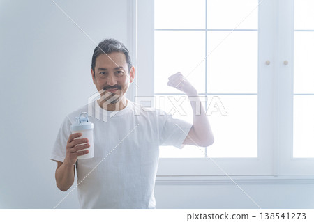一位中年男子手持一瓶蛋白粉。 一位中年男子手持一瓶蛋白粉。 138541273