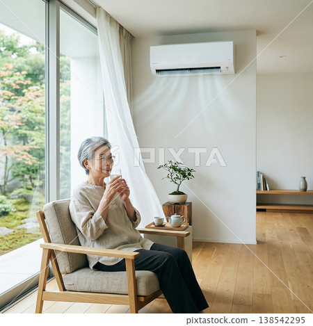 An elderly woman coolly drinks water in a comfortable, air-conditioned room. 138542295