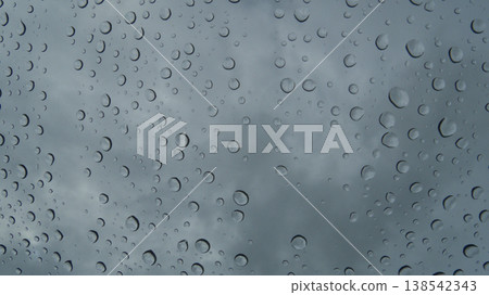 Raindrops on the windshield inside a car on a rainy day, and the dark scenery outside. Raindrops on the windshield inside a car on a rainy day, and the dark scenery outside. 138542343