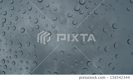 Raindrops on the windshield inside a car on a rainy day, and the dark scenery outside. Raindrops on the windshield inside a car on a rainy day, and the dark scenery outside. 138542344