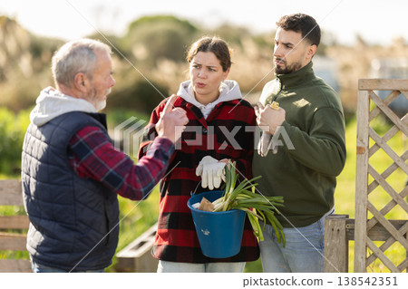 On bright spring day, middle-aged couple swear with senior man neighbor On bright spring day, middle-aged couple swear with senior man neighbor 138542351