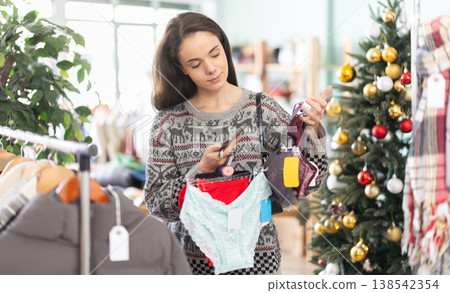 Girl interesting goods, scans QR code and label of lingerie, X mas shopping 138542354