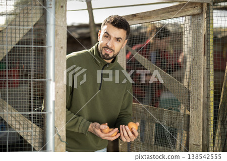 Man holding fresh eggs in chicken coop 138542555