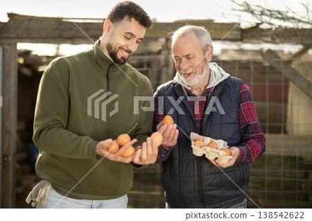 Man with senior father presents farms eco-friendly products - chicken eggs 138542622