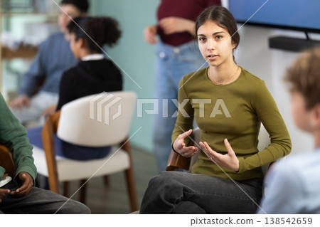 Teenage girl participating in group communication Teenage girl participating in group communication 138542659
