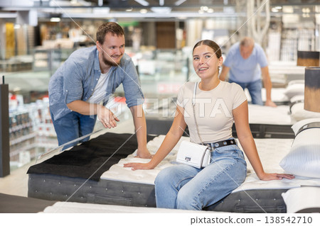 Couple man and woman choosing bed in store Couple man and woman choosing bed in store 138542710