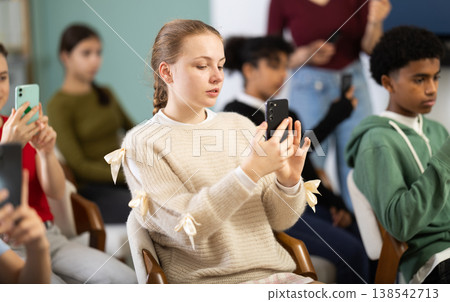 European teen girl scans a barcode on a mobile app to get more materials 138542713