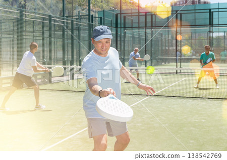 Adult and young men playing padel against two men Adult and young men playing padel against two men 138542769