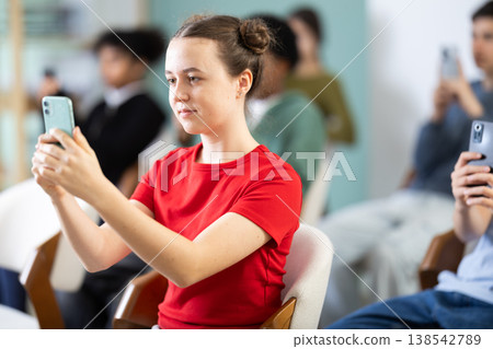 Teenagers listeners take photos of presentation slide or scan QR code. Teenagers listeners take photos of presentation slide or scan QR code. 138542789