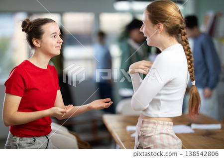 Two teenage girls communicate in a circle in a school 138542806