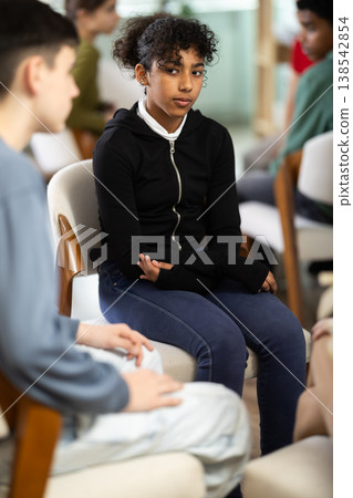 Afro American girl sits in a school classroom with teenagers, they communicate and do practical classes Afro American girl sits in a school classroom with teenagers, they communicate and do practical classes 138542854