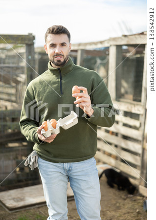 Man holding fresh eggs in chicken coop 138542912