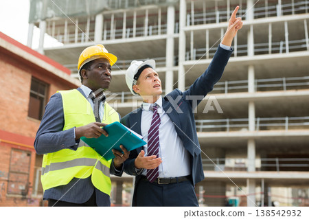 Young architect discusses a construction plan with an engineer 138542932
