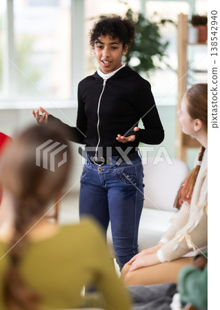 African American girl speaks to a group at a school class African American girl speaks to a group at a school class 138542940