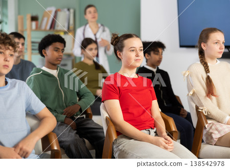 Schoolchildren carefully watch a lecture in the classroom against the background of a a doctor teacher Schoolchildren carefully watch a lecture in the classroom against the background of a a doctor teacher 138542978