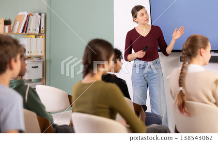 Teacher conducts a lesson in front of a group of students, explaining the material at the screen 138543062