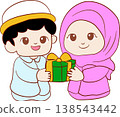 Cute Muslim boy and girl in traditional clothes holding gift 138543442