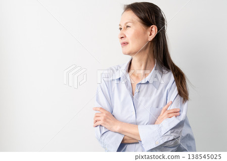 A senior woman in casual clothes standing – a lifestyle image. A senior woman in casual clothes standing – a lifestyle image. 138545025
