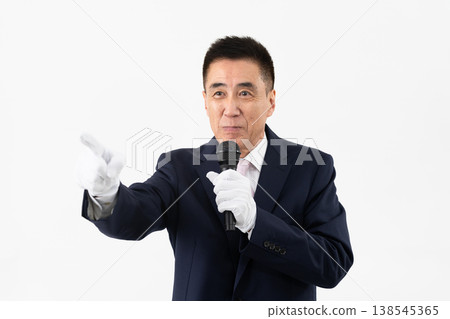 Senior man giving a campaign speech while holding a microphone Senior man giving a campaign speech while holding a microphone 138545365