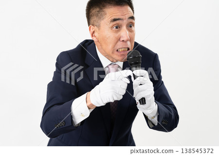 Senior man giving a campaign speech while holding a microphone Senior man giving a campaign speech while holding a microphone 138545372