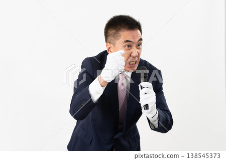 Senior man giving a campaign speech while holding a microphone Senior man giving a campaign speech while holding a microphone 138545373