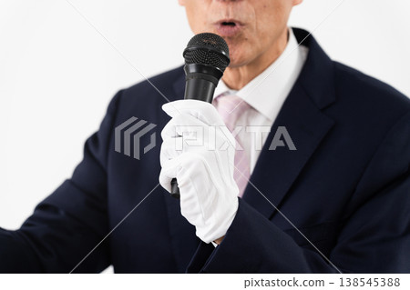 Senior man giving a campaign speech while holding a microphone Senior man giving a campaign speech while holding a microphone 138545388