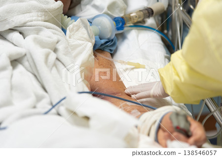 Close up of patient in hospital bed with IV line and ventilation support showing intensive care treatment monitoring and emergency healthcare environment 138546057
