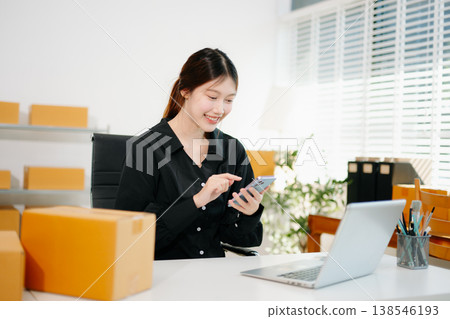 Young business owner woman prepare parcel box and standing check online orders for deliver to customer on tablet, laptop Shopping Online concept. 138546193