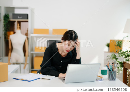 Stressed Asian woman sitting at office desk with parcels and laptop, overwhelmed by online business problems, workload pressure Stressed Asian woman sitting at office desk with parcels and laptop, overwhelmed by online business problems, workload pressure 138546308