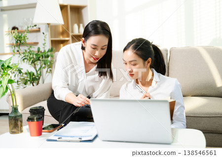 Two businesswomen discussing ideas while working with laptop at home office. Remote work, teamwork, collaboration, startup meeting and modern business lifestyle. Two businesswomen discussing ideas while working with laptop at home office. Remote work, teamwork, collaboration, startup meeting and modern business lifestyle. 138546561