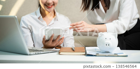 Smiling couple managing savings and budget at home with piggy bank, laptop and calculator. Personal finance, investment planning and smart money management Smiling couple managing savings and budget at home with piggy bank, laptop and calculator. Personal finance, investment planning and smart money management 138546564