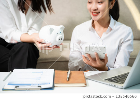 Smiling couple managing savings and budget at home with piggy bank, laptop and calculator. Personal finance, investment planning and smart money management Smiling couple managing savings and budget at home with piggy bank, laptop and calculator. Personal finance, investment planning and smart money management 138546566