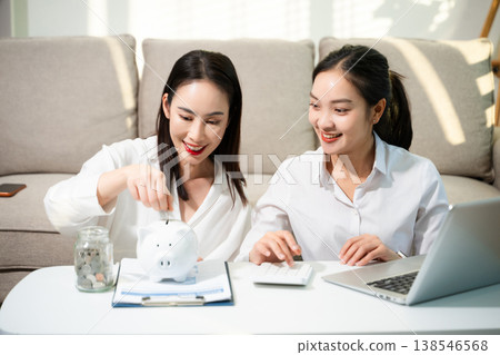 Smiling couple managing savings and budget at home with piggy bank, laptop and calculator. Personal finance, investment planning and smart money management Smiling couple managing savings and budget at home with piggy bank, laptop and calculator. Personal finance, investment planning and smart money management 138546568