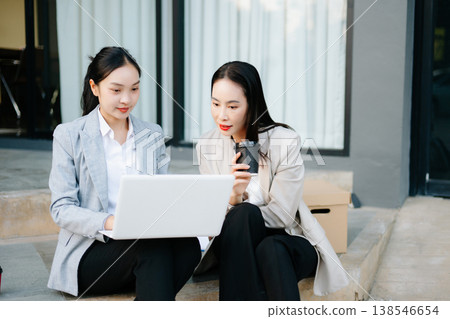 Businesswoman and woman going in city center in smart casual business style, talking, working together, stylish freelance people, holding coffee Businesswoman and woman going in city center in smart casual business style, talking, working together, stylish freelance people, holding coffee 138546654