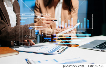 Businesswoman team Project manager working and update tasks and Gantt chart scheduling virtual diagram.with smart phone, tablet 138546736
