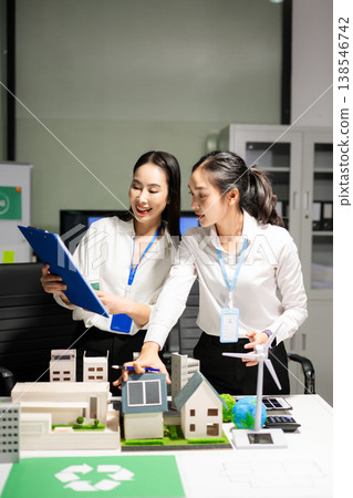 Business professionals planning renewable energy strategy with solar panels and wind turbine model. Sustainability, ESG, green innovation and net zero 138546742